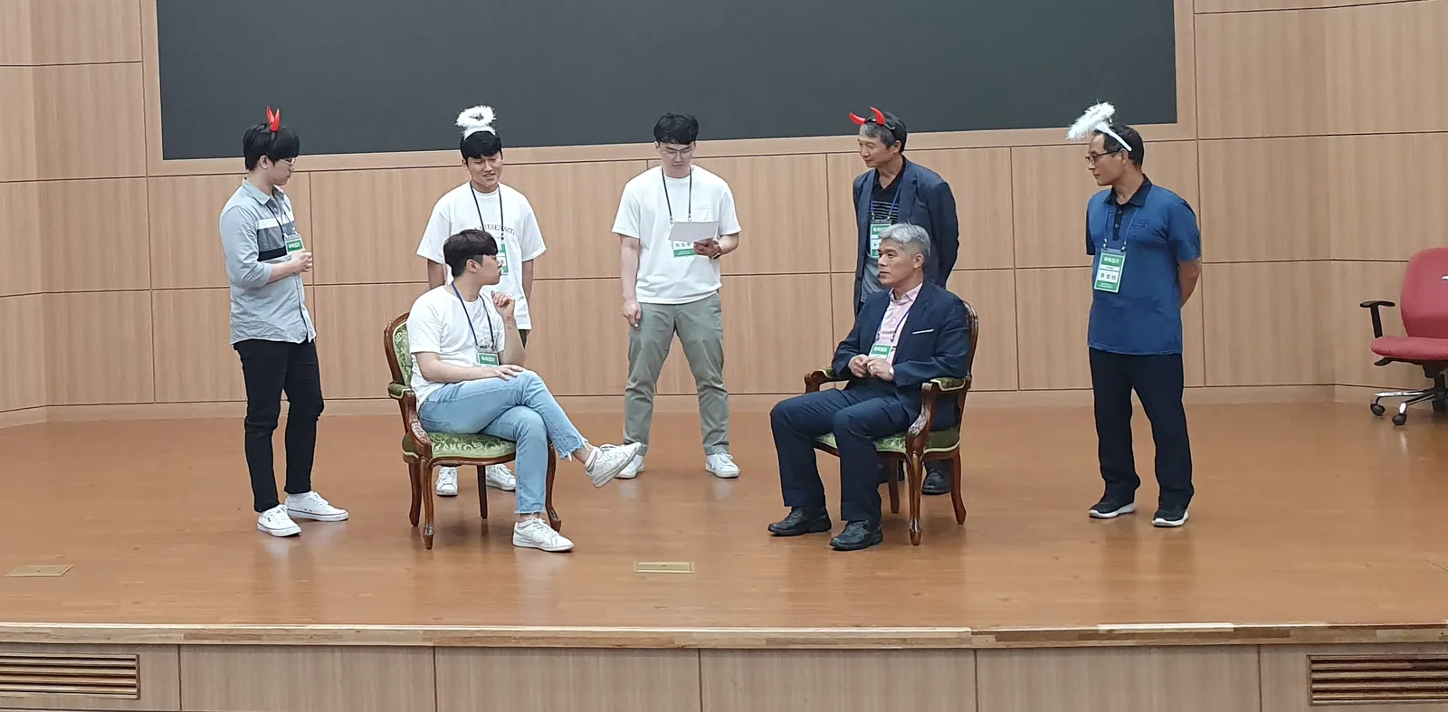 포스코 인재창조원 소통 역할극. 직원들이 무대 위 의자에 앉고 서서 장면을 연기하고 있다