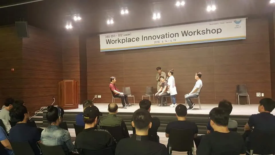 SPC삼립 중간관리자 갈등관리 역할극. 무대 위에서 직원들이 장면을 연기하고 객석의 동료들이 지켜본다